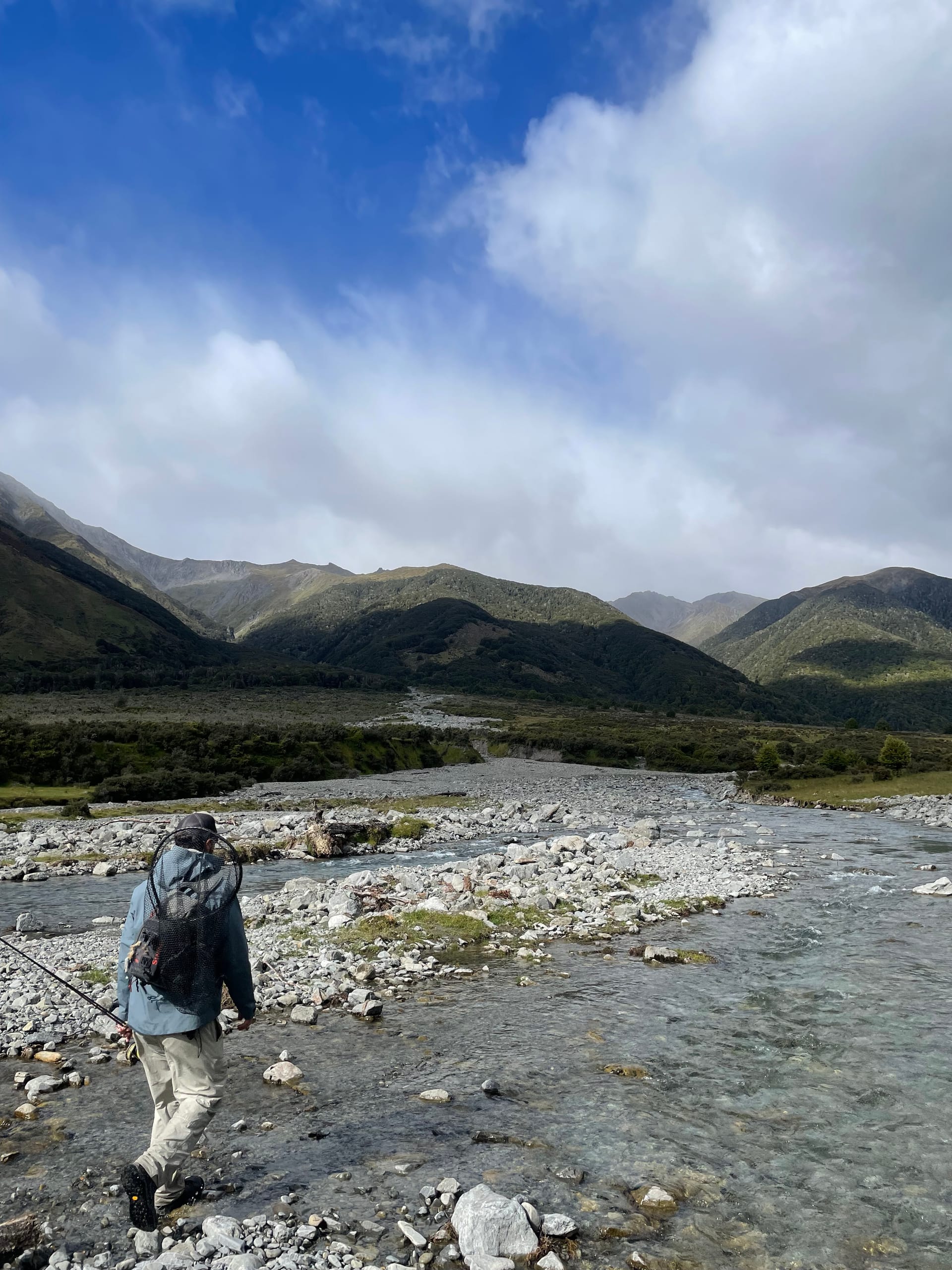 Angler walking into a remote South Island backcountry river valley